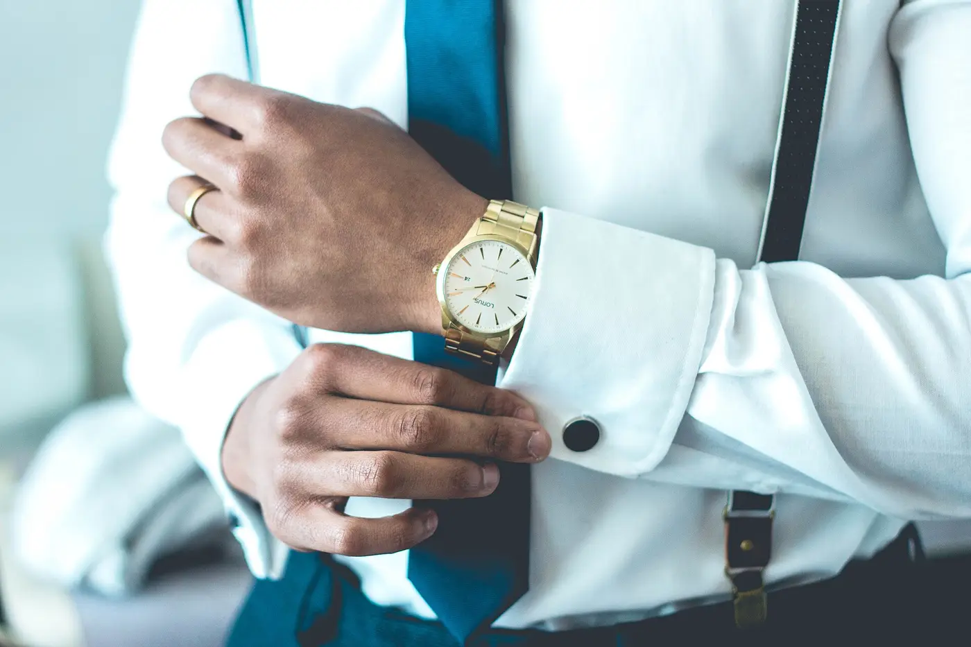 Montre dorée au poignet d'une chemise blanche